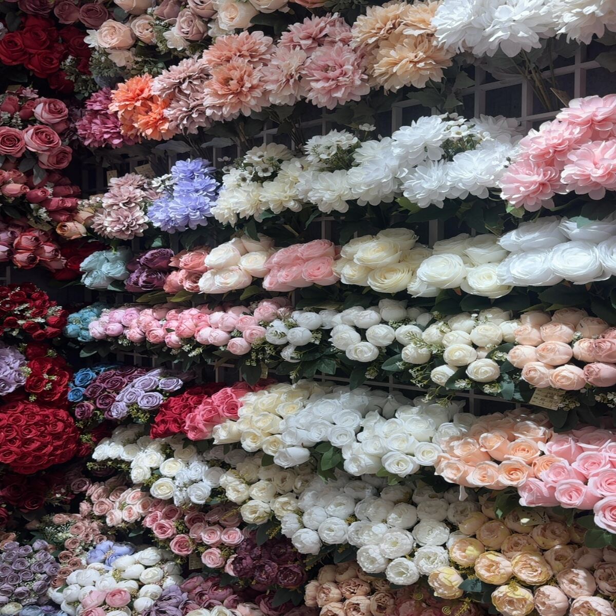 Assortment of artificial roses, peonies, та mixed flowers in various colors on display.